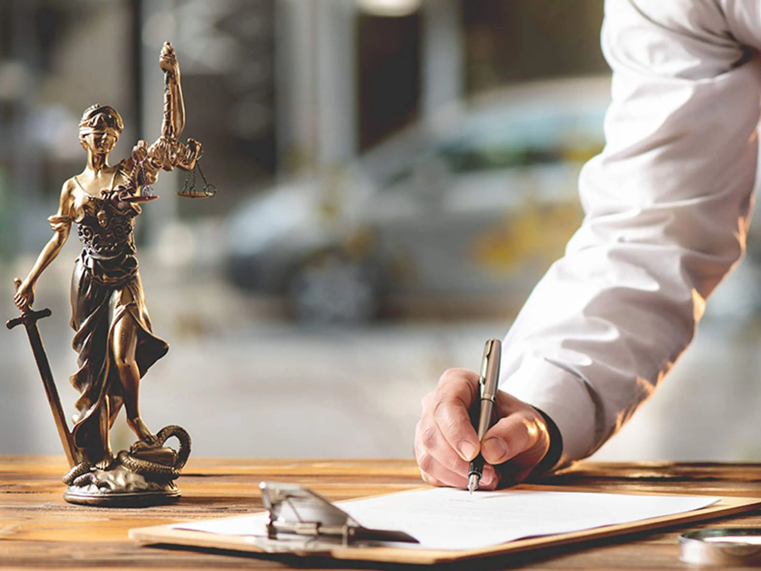signature contrat notaire avec statuette justice