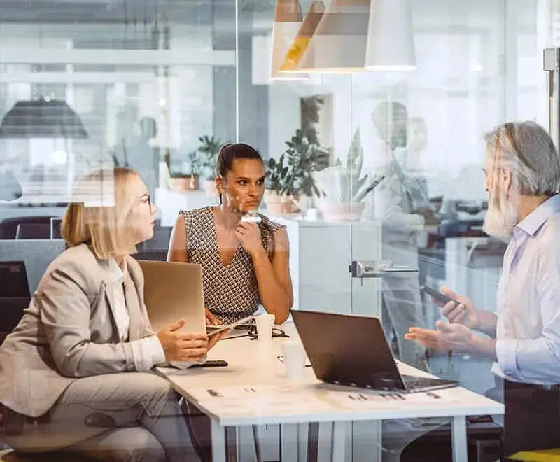 réunion expertise rh et sociale entre 3 personnes dans un bureau